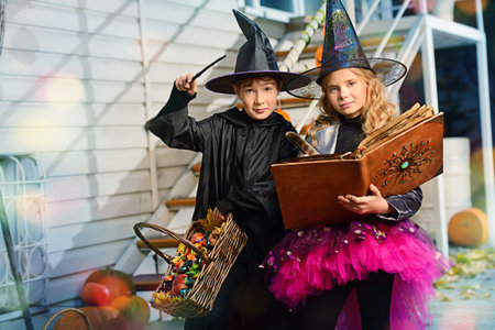 Happy children in a costumes of witches and wizards celebrating halloween. Trick or treat. Halloween party.の写真素材