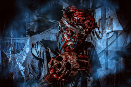 Bloodthirsty zombie chewing the skull of his victim. Halloween concept.の写真素材