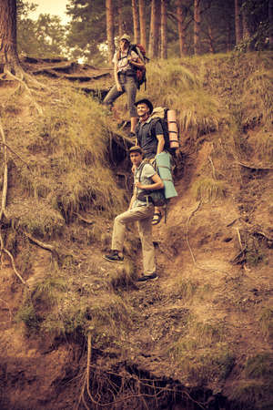 Adventure and hiking. Group of young people make a hike in mountains. Active lifestyle. Tourist equipment.の写真素材