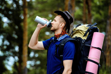 Adventure concept. Young man hiking in the forest. Active lifestyle, tourism. Tourist equipment.の写真素材
