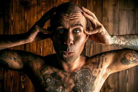 Yoga concept. Emotional yoga. Mature man doing yoga exercises and meditation over wooden background.の写真素材