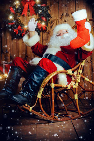 Good old Santa Claus with Christmas gifts at his wooden house. Sepia.の写真素材