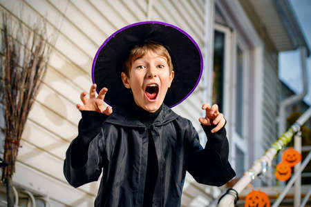 A boy in a costume of wizard with his magic wand is going to a halloween party. Trick or treat. Halloween concept.の写真素材