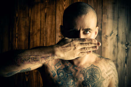 Yoga concept. Emotional yoga. Mature man doing yoga exercises and meditation over wooden background.の写真素材