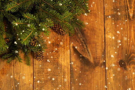 Christmas Corner - a strip of fresh fluffy fir branches with cones on a wooden background.の写真素材