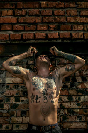 Experienced yoga man doing various yoga poses outdoor by the brick wall. Yoga concept.の写真素材