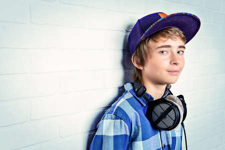 Modern teenage boy enjoys the music in headphones. Studio shot. Youth culture.の写真素材