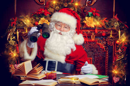 Santa Claus is preparing for Christmas, he looks through binoculars. House of Santa Claus. Christmas decoration.の写真素材