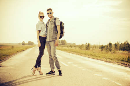 Fashionable models wearing jeans clothes posing on a highway. Denim style. Sepia, retro styled.の写真素材