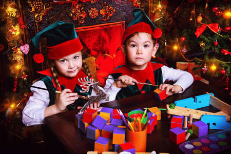 Little fairy elves make gifts for children at Christmas. Workshop of Santa Claus. Christmas concept.の写真素材