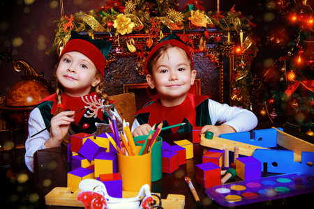Little fairy elves make gifts for children at Christmas. Workshop of Santa Claus. Christmas concept.の写真素材
