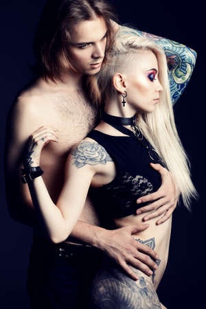 Sexual couple play in love games. Attractive young woman with her handsome boyfriend. Bright make-up, cosmetics. Tattoo. Love concept.の写真素材