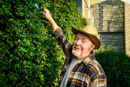 Senior man trimming garden plants. Gardening concept. Happy retirement.