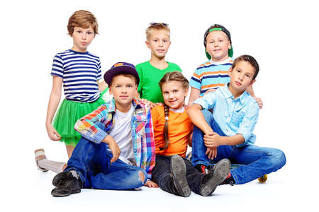 Group of happy children posing together at studio. Kid's fashion. Education. Isolated over white.の写真素材