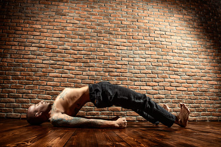 An experienced yoga instructor showing different yoga poses. Brick wall background. Healthy lifestyle. Meditation, concentration.の写真素材