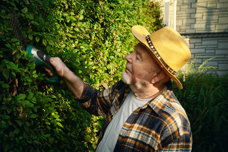 Senior man trimming garden plants. Gardening concept. Happy retirement.