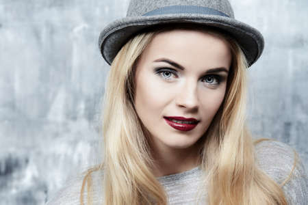 Pretty woman portrait. Attractive young woman with blonde hair wearing hat. Beauty, fashion concept. Cosmetics.の写真素材