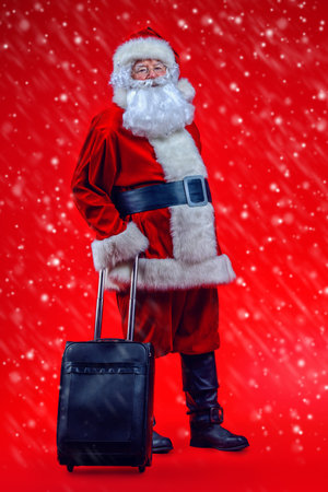 Christmas, tourist trip concept. Santa Claus with suitcase is going to travel around the planet. Christmas time. Time for miracles. Copy space.の写真素材