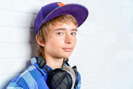 Modern teenage boy enjoys the music in headphones. Studio shot. Youth culture.の写真素材