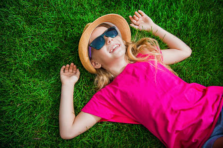 Happy smiling girl enjoys her summer holidays. Summer park. Happy childhood.の写真素材