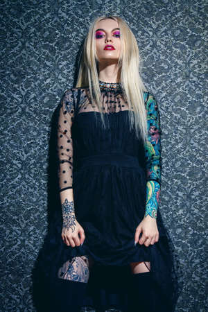 Extravagant attractive woman with bright make-up and long blonde hair. Beauty, fashion concept. Cosmetics, make-up. Vintage wallpaper.の写真素材