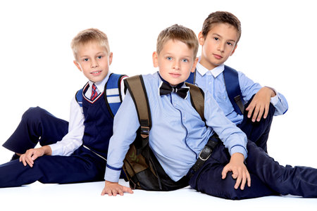 Three schoolboys posing together in school uniform. Educational concept. Isolated over white.