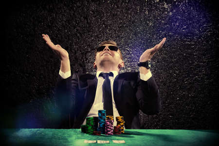 Lucky man playing cards and roulette with the excitement in casino.の写真素材