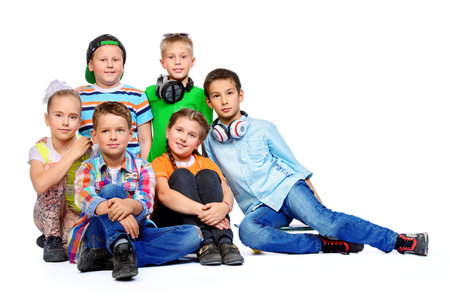 Group of happy children posing together at studio. Isolated over white.