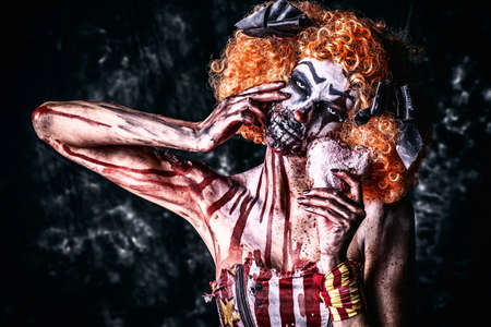 Close-up portrait of a terrible bloody clown with a mask. Halloween. Horror.の写真素材