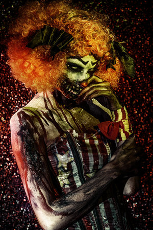 Evil clown murderer stained in blood. Female zombie clown. Halloween. Horror.の写真素材