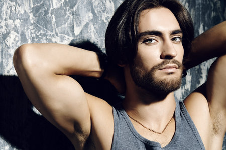 Portrait of a handsome masculine man over grunge background. Hairstyle, barbershop.