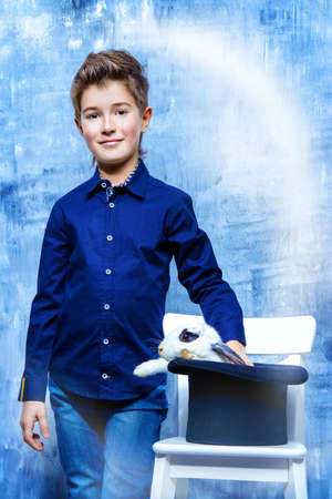 Kid's fashion. Modern nine year old boy posing with rabbit. Clothes for children. Easter holidays.の写真素材