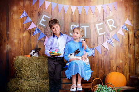 Easter holidays. Happy children posing with Easter Bunny and painted eggs in Easter decorations.