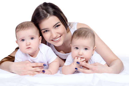Beautiful happy mother playing with her baby children. Family concept. Healthy children. Isolated over white.の写真素材
