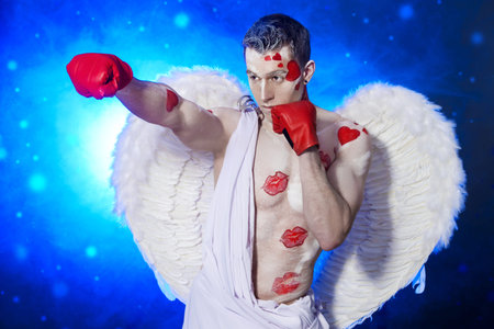 Male angel Cupid covered with kisses wearing boxing gloves. Valentine's day. Love concept.