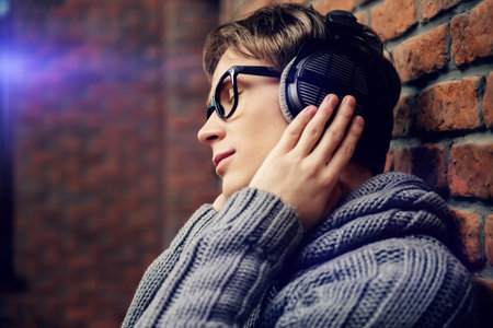 Happy young man listens to music in headphones at home. Radio music, DJ.