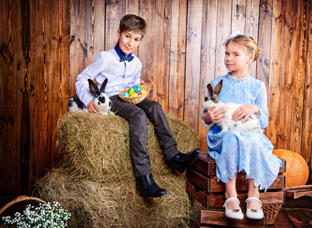 Easter holidays. Happy children posing with Easter Bunny and painted eggs in Easter decorations.の写真素材