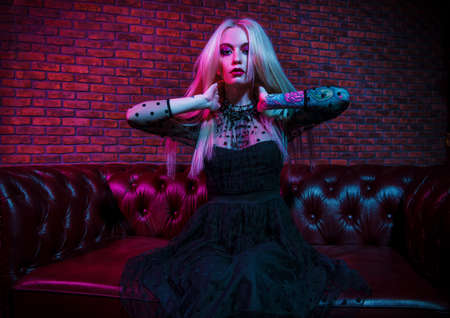 Portrait of an extravagant attractive woman with bright make-up and long blonde hair. Beauty, fashion concept. Cosmetics, make-up. Gothic style.の写真素材