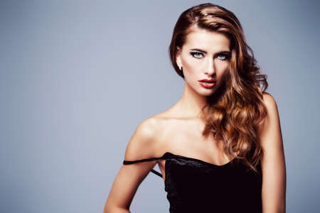 Portrait of a beautiful young woman with dark make-up and wavy hair. Femininity. Sexual woman. Beauty, fashion and cosmetics concept.の写真素材