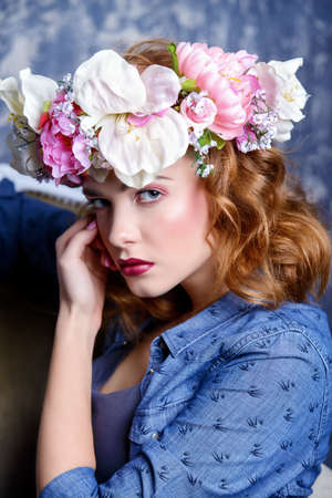 Modern young woman wearing casual jeans clothes and wreath of flowers. Cosmetics and make-up. Spring and summer fashion.の写真素材