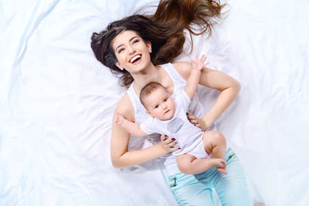 Happy young mother playing with her small baby. Family concept. Healthcare, pediatrics.の写真素材