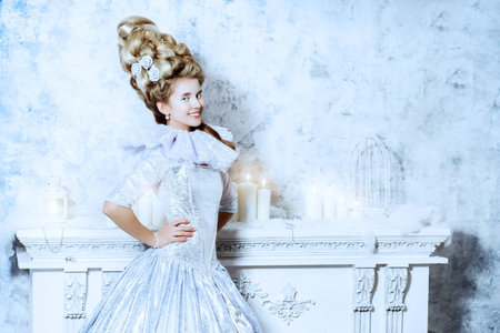 Elegant young woman in a lush white medieval dress with hair in the style of the Renaissance....