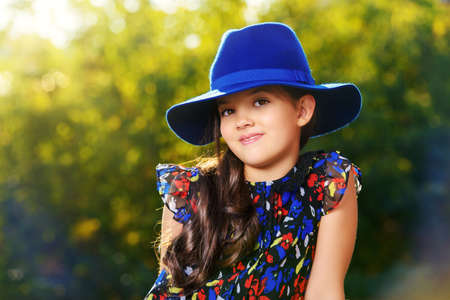 Happy eight year girl outdoor on a bright sunny day. Summer holidays. Kid's fashion.の写真素材