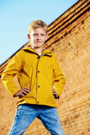 Cool modern eight-year boy posing over blue sky. Kid's fashion.の写真素材