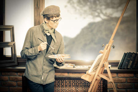 Inspired artist man draws a picture in the workshop. Arts and painting.の写真素材