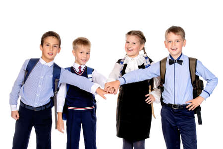 Portrait of happy school friends posing together at studio. School uniform. Education. Isolated over white.の写真素材