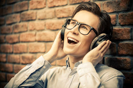 Happy young man listens to music in headphones at home. Radio music, DJ.の写真素材