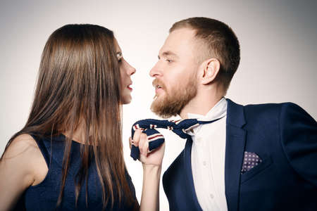 Close-up portrait of a beautiful young woman pulls to herself the man. Beauty, fashion. Love concept.の写真素材