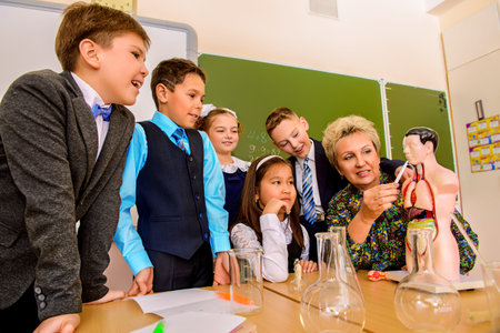 Favorite teacher. Portrait of students with their teacher during the lesson. Educational concept.
