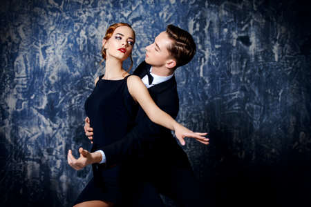 Beautiful passionate dancers dancing tango. Professional dancers. Couple in love dancing on a date. Love concept.の写真素材
